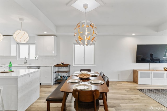 dining space featuring an inviting chandelier, light wood-style flooring, baseboards, and recessed lighting