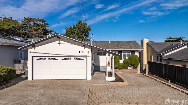 ranch-style home featuring concrete driveway, an attached garage, fence, and stucco siding