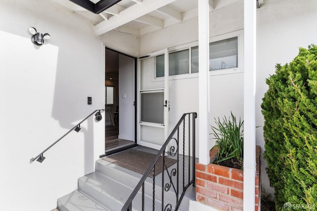 doorway to property featuring stucco siding