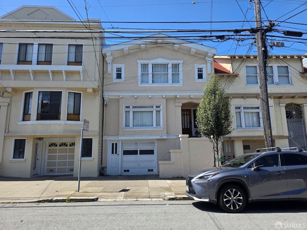 view of property featuring stucco siding, driveway, and a garage