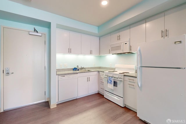 kitchen featuring white appliances, white cabinets, light hardwood / wood-style flooring, and sink