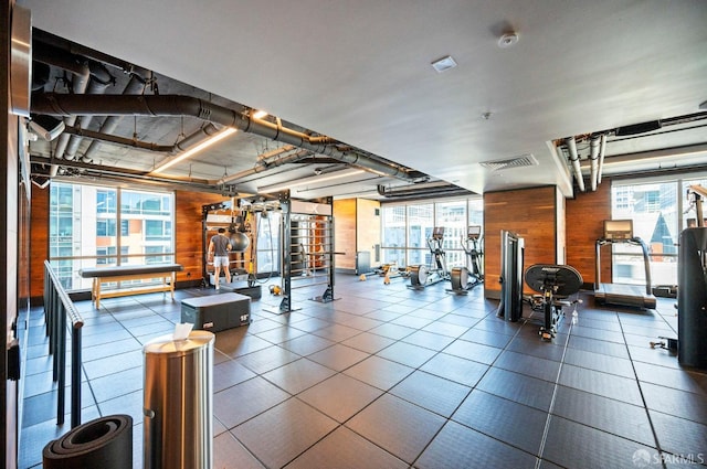 exercise room featuring a wealth of natural light and wooden walls