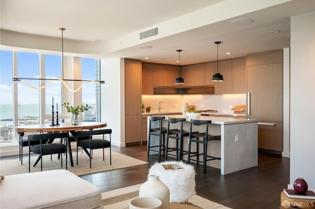 living room with dark wood-type flooring, sink, and a water view