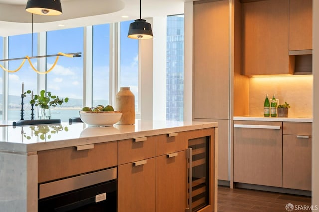 kitchen featuring decorative light fixtures, a wealth of natural light, beverage cooler, and dark hardwood / wood-style flooring