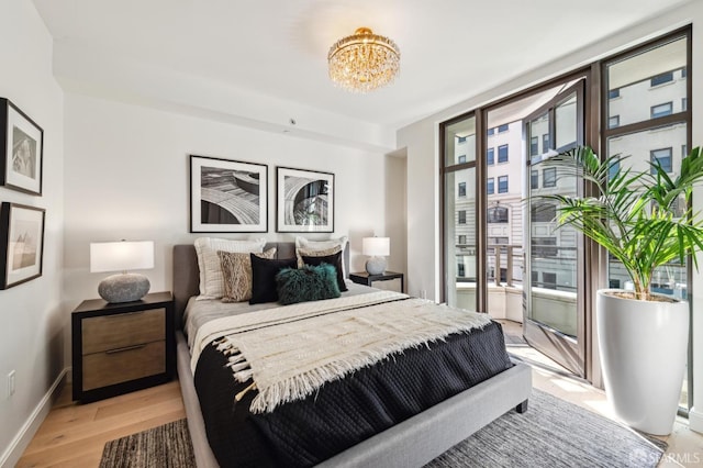 bedroom featuring a notable chandelier and light hardwood / wood-style flooring