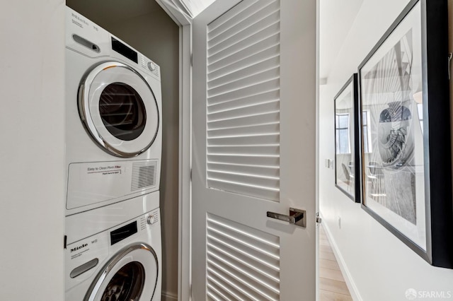 washroom featuring stacked washer and clothes dryer