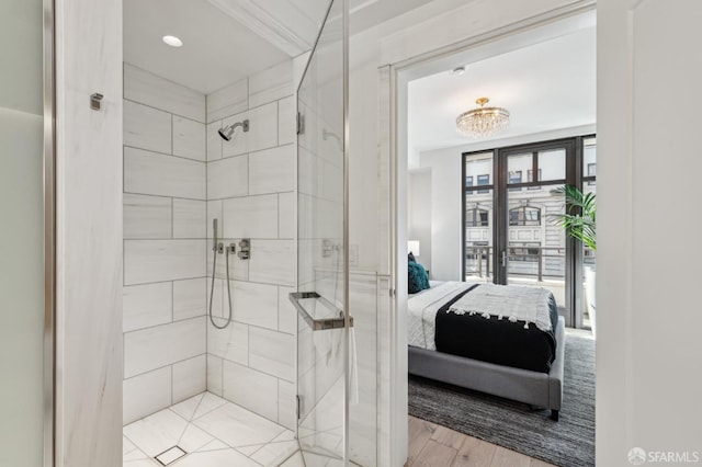 bathroom with a tile shower and wood-type flooring