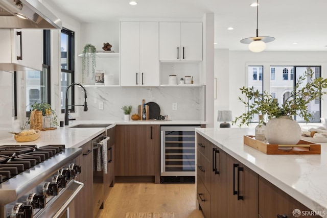 867 33rd Ave, San Francisco, CA 94121 - kitchen with open shelves, wine cooler, wall chimney exhaust hood, light wood-style floors, and white cabinets