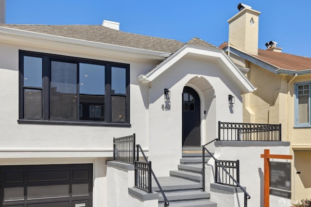 867 33rd Ave, San Francisco, CA 94121 - property entrance featuring a chimney, stucco siding, a garage, and roof with shingles