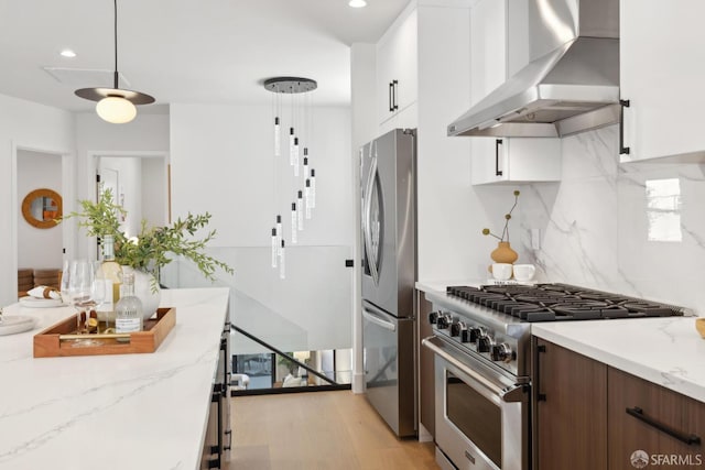867 33rd Ave, San Francisco, CA 94121 - kitchen featuring wall chimney exhaust hood, appliances with stainless steel finishes, white cabinetry, decorative backsplash, and light wood-type flooring