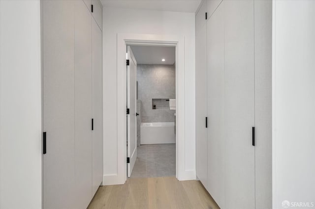 hallway with light hardwood / wood-style floors