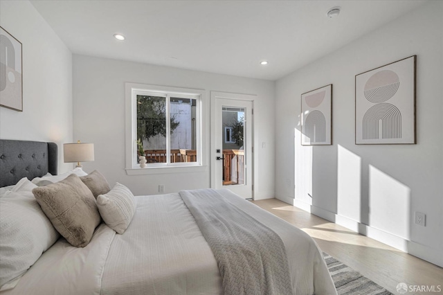 bedroom with access to exterior and light hardwood / wood-style floors