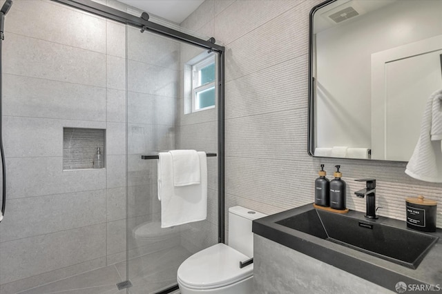 bathroom featuring decorative backsplash, sink, toilet, and a shower with shower door