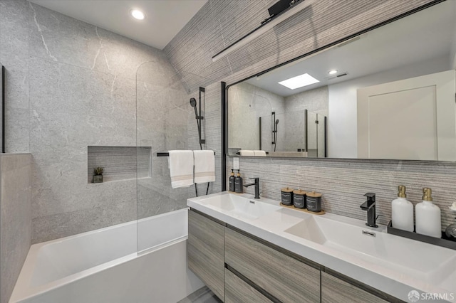 bathroom featuring decorative backsplash, tiled shower / bath combo, and vanity