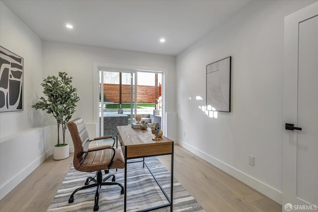 home office with light hardwood / wood-style floors