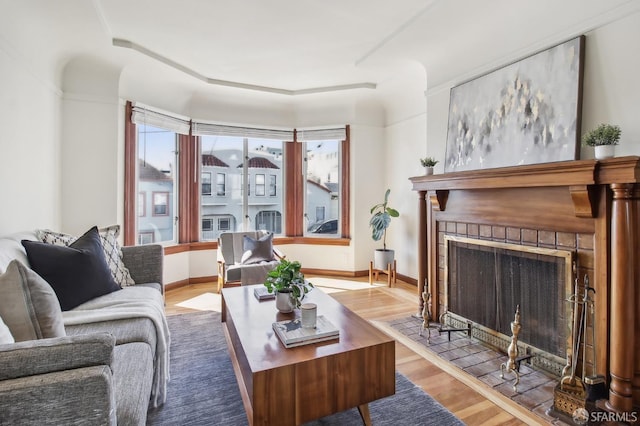 living room with a fireplace with flush hearth and wood finished floors