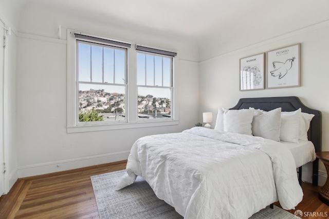 bedroom featuring baseboards and wood finished floors