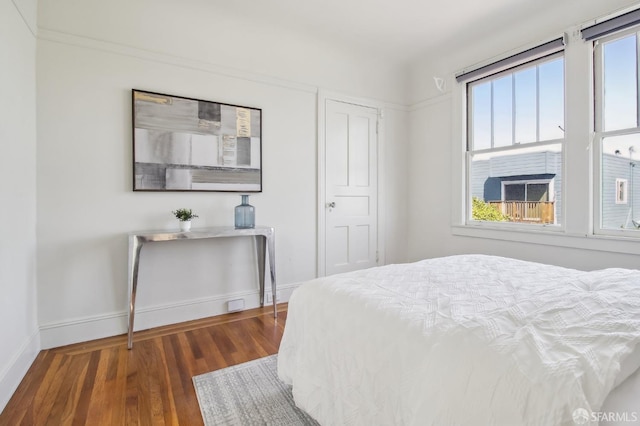 bedroom featuring baseboards and wood finished floors