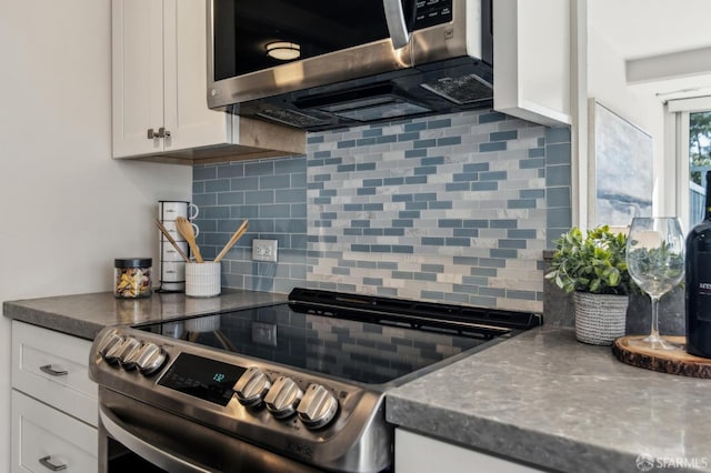 kitchen featuring appliances with stainless steel finishes, white cabinets, and backsplash