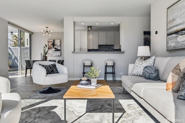 living room with a notable chandelier, wood-type flooring, and floor to ceiling windows