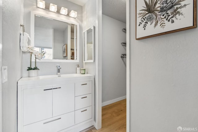 bathroom featuring vanity, wood-type flooring, and a textured ceiling