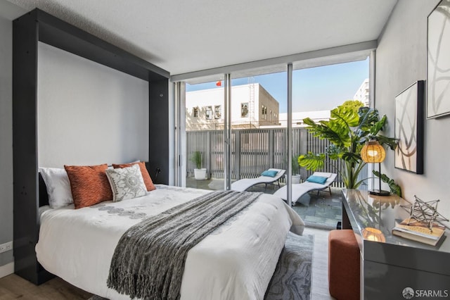 bedroom featuring expansive windows and access to outside