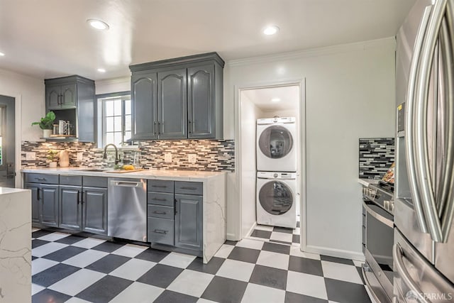 718 Whipple Ave, Redwood City, CA 94063 - kitchen featuring appliances with stainless steel finishes, stacked washing machine and dryer, dark floors, gray cabinetry, and crown molding