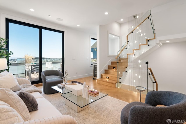 living room with wine cooler, light parquet flooring, and a water view