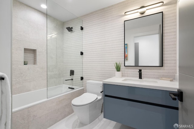 full bathroom featuring tiled shower / bath, vanity, and toilet