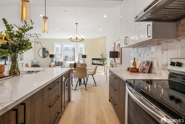 2219 Bryant St, San Francisco, CA 94110 - kitchen featuring white cabinets, hanging light fixtures, ventilation hood, stainless steel electric range oven, and light wood-type flooring