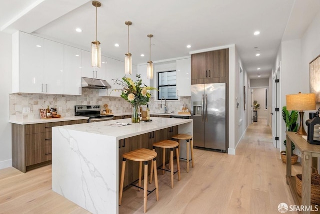 kitchen featuring a center island, white cabinetry, decorative backsplash, sink, and stainless steel appliances