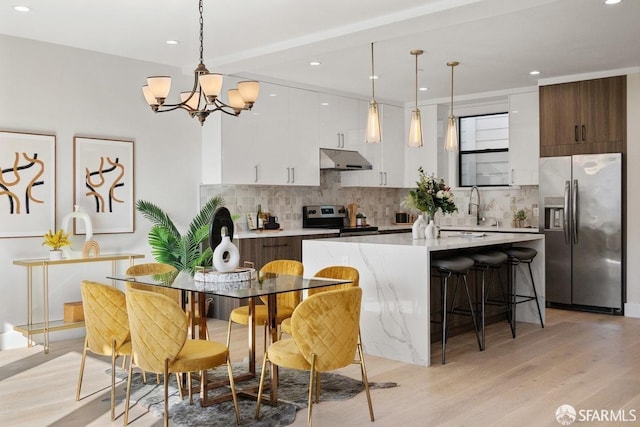 2219 Bryant St, San Francisco, CA 94110 - kitchen featuring tasteful backsplash, pendant lighting, a center island, and appliances with stainless steel finishes