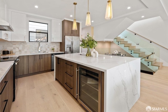 2219 Bryant St, San Francisco, CA 94110 - kitchen featuring white cabinetry, appliances with stainless steel finishes, a kitchen island, and wine cooler