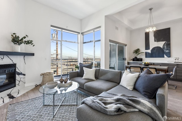 608 Missouri St Unit A, San Francisco, CA 94107 - living area featuring wood finished floors, a premium fireplace, baseboards, a chandelier, and a towering ceiling