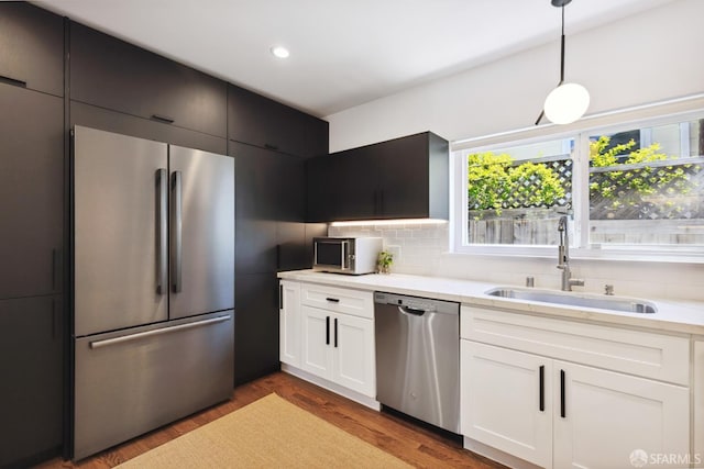 2464 Alida St, Oakland, CA 95602 - kitchen with appliances with stainless steel finishes, tasteful backsplash, wood finished floors, hanging light fixtures, and recessed lighting
