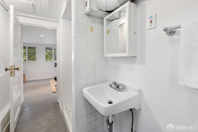 bathroom featuring baseboards and a sink