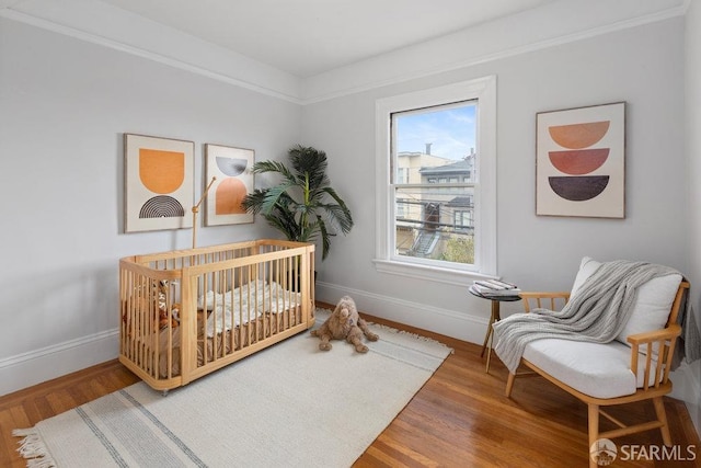 bedroom featuring wood finished floors and baseboards