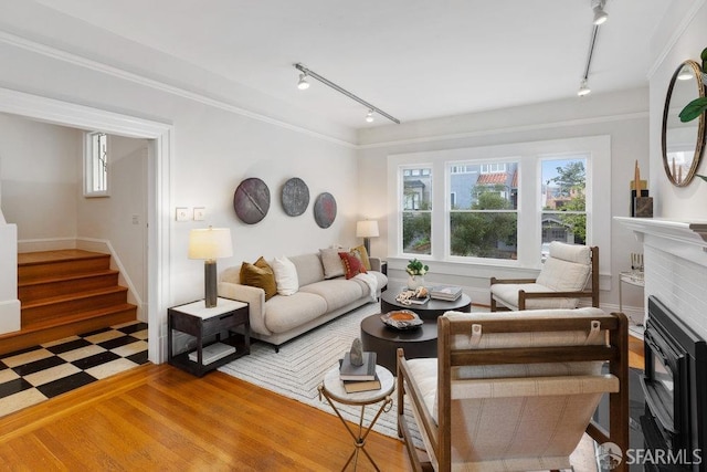 living room featuring stairs, a fireplace, ornamental molding, track lighting, and tile patterned floors