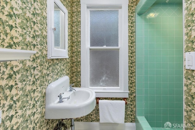 full bathroom featuring wallpapered walls and a sink