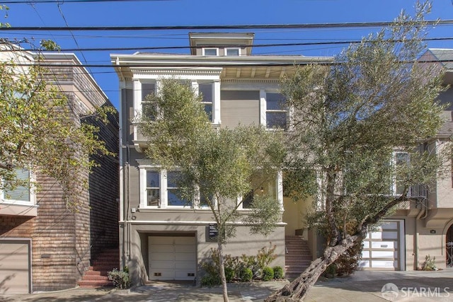 view of front of home featuring stairway, an attached garage, and stucco siding