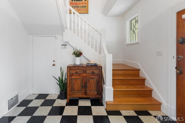 staircase with baseboards, visible vents, and tile patterned floors