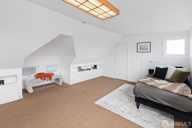 carpeted bedroom with lofted ceiling and baseboards