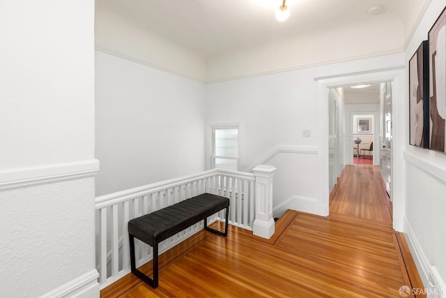 hallway with a wealth of natural light, wood finished floors, and an upstairs landing