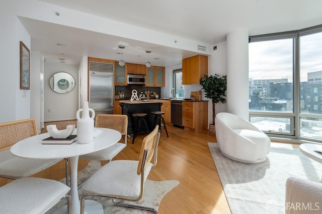 dining space with light hardwood / wood-style flooring and sink