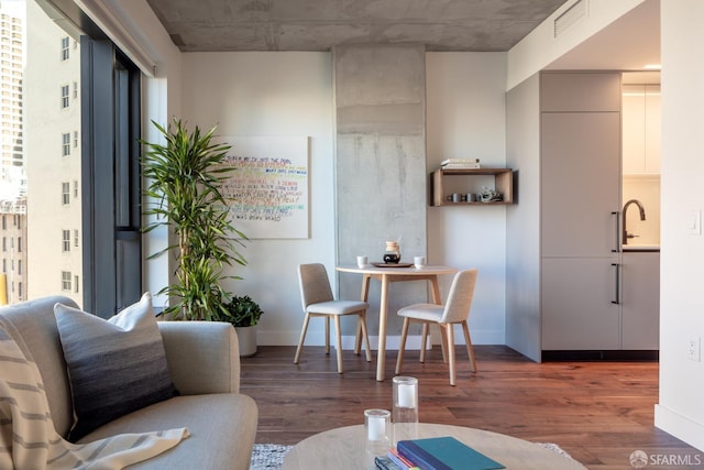 living area with baseboards, visible vents, and wood finished floors