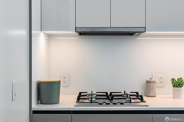 interior details with light countertops and stainless steel gas cooktop