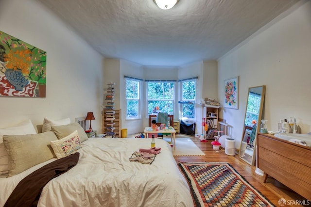 bedroom featuring hardwood / wood-style flooring and a textured ceiling