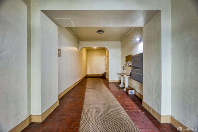 hallway featuring ornamental molding and a mail area