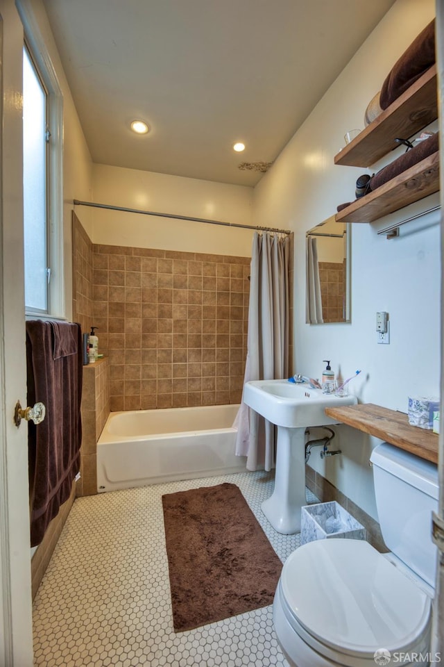 bathroom with plenty of natural light, toilet, tile patterned flooring, and shower / tub combo