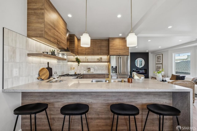 57 Niagara Ave, San Francisco, CA 94112 - kitchen featuring stainless steel refrigerator with ice dispenser, wall chimney exhaust hood, a peninsula, tasteful backsplash, and recessed lighting